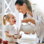 mamá brindando cereal a su hija