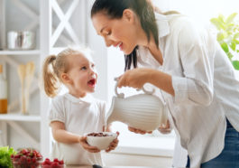 mamá brindando cereal a su hija