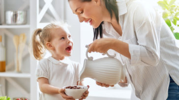 mamá brindando cereal a su hija