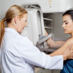 mujer haciéndose la mamografia
