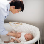 mamá cuidando bebé en cuna