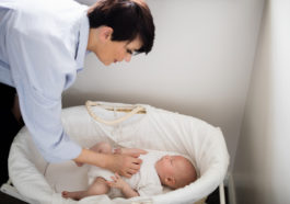 mamá cuidando bebé en cuna