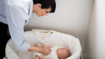 mamá cuidando bebé en cuna