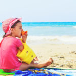 niño comiendo en la playa