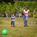 mamá jugando a la pelota con hijo