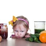 niña malgeniada por comer verduras