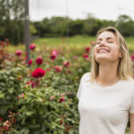mujer sintiendo el aroma del jardin