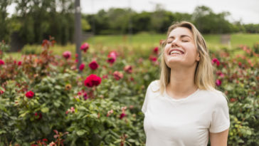 mujer sintiendo el aroma del jardin